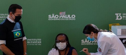 D&oacute;ria observa M&ocirc;nica Calazans recebendo a CoronaVac (Arquivo Blasting News).