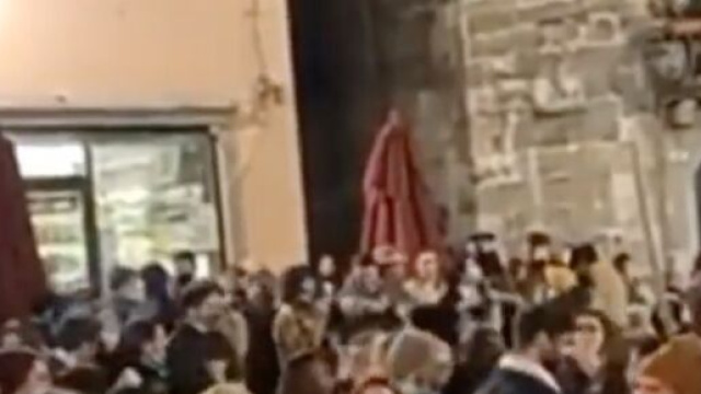 Assembramenti in piazza a Lucca, mascherine abbassate o assenti.
