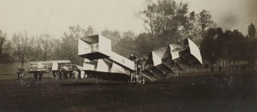 Alberto Santos Dumont com o seu 14 Bis (Jules Beau/Dom&iacute;nio p&uacute;blico)