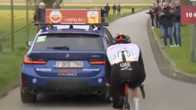 Ciclismo, Tadej Pogačar in scia alla macchina della direzione di corsa dell'Amstel Gold Race.