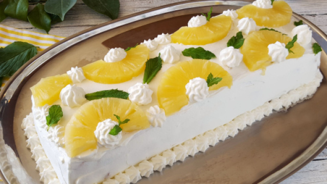 Una torta con ananas, crema e panna