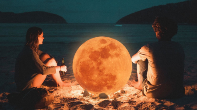 Coppia in riva al mare con lampada simil lunare - &copy; Pixabay.