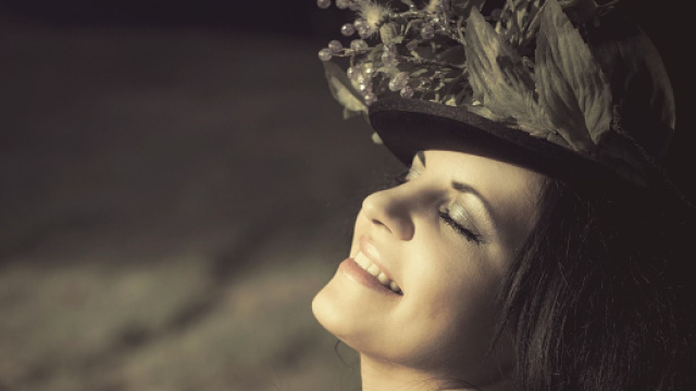 Donna sorridente indossa un originale cappellino - &copy; Pixabay.