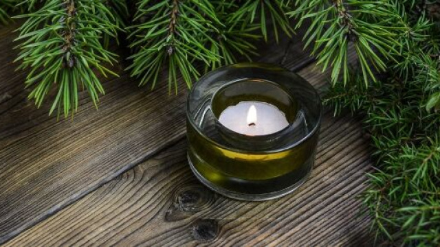 Una candela vicino un albero di Natale (&copy;pixabay.com)