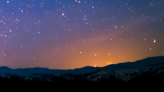 Aurora dietro a dei monti e cielo stellato &copy; Pexels