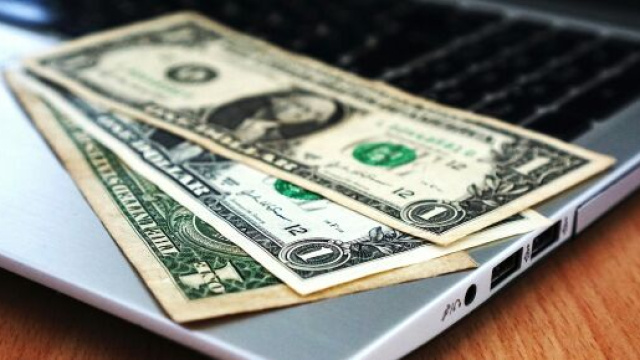 Un computer e delle banconote &copy; Pexels.com