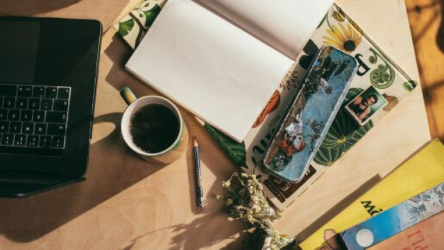 Scrivania con computer, libri e caff&egrave;- &copy; Pexels.