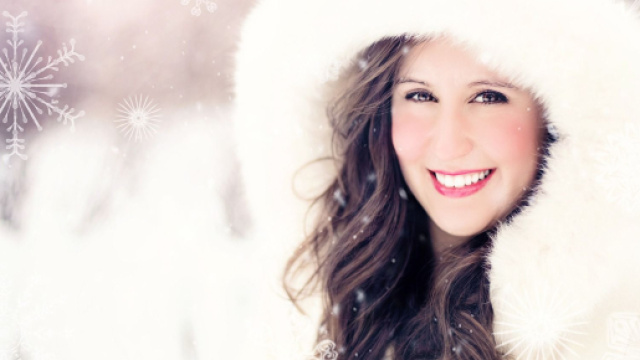 Donna con pelliccia bianca sorridente &copy; Pixabay.