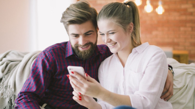 Coppia felice guarda le foto sul telefonino - &copy; Foto Pixbay