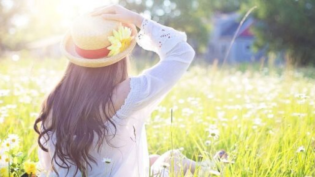 Una ragazza e un prato fiorito (&copy; Pixabay).