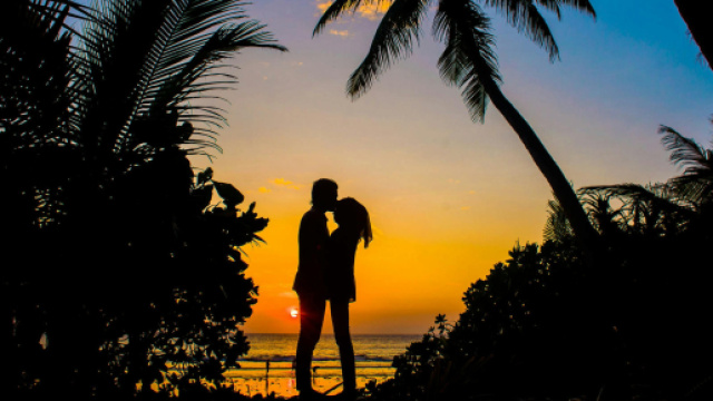Tramonto con due innamorati in spiaggia - &copy; Pexels.