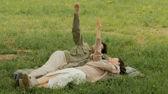 Uomo e donna distesi su un prato - &copy; Pexels.com