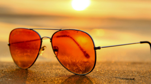 Occhiali da sole in una spiaggia (&copy; Pexels).