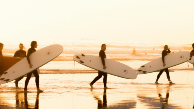 Surfisti in spiaggia d'estate - &copy;Pexels.