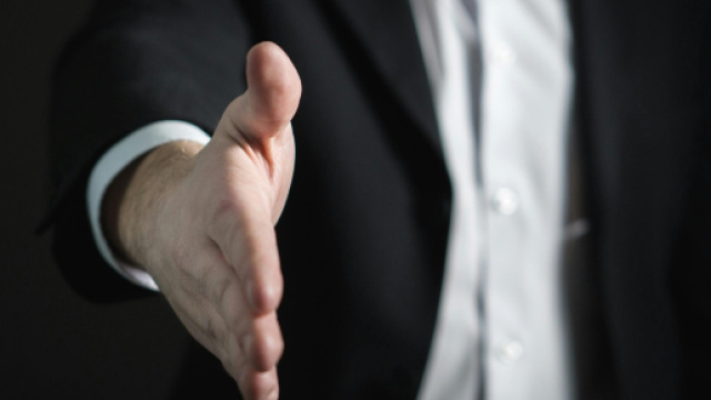 Uomo in giacca che tende la mano - &copy; Pexels