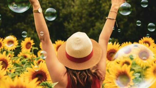 Donna di spalle in un un campo di girasoli - &copy; Pexels.com