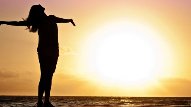 Donna felice con sole al tramonto - &copy; Pixabay.