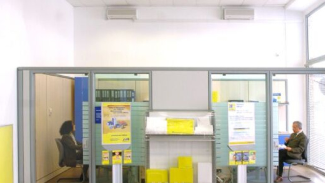 In foto due impiegati di &copy; Poste Italiane.