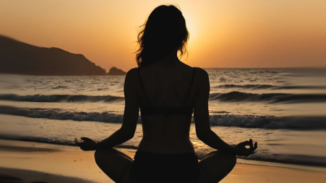 Figura femminile in meditazione sulla spiaggia al tramonto - &copy; Pixabay.