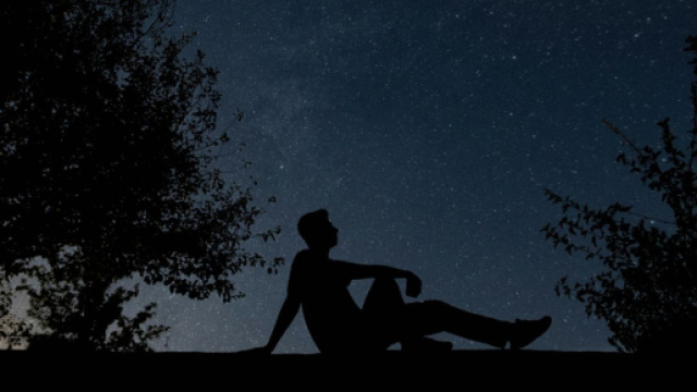 Uomo all'aperto sotto un cielo di stelle - &copy; Pixabay.