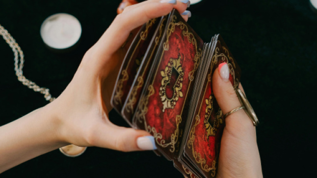 Mani che mischiano le carte- &copy; Pexels.