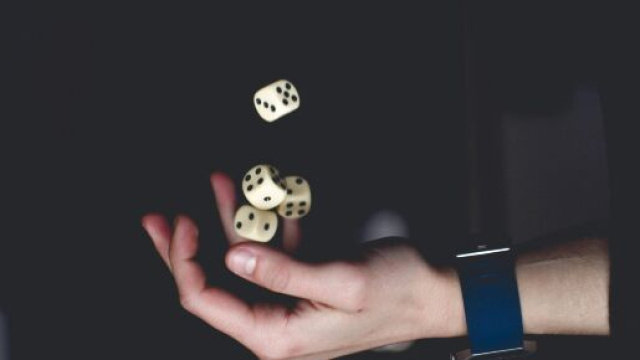 Persona con quattro dadi &copy; Immagine di Pexels.