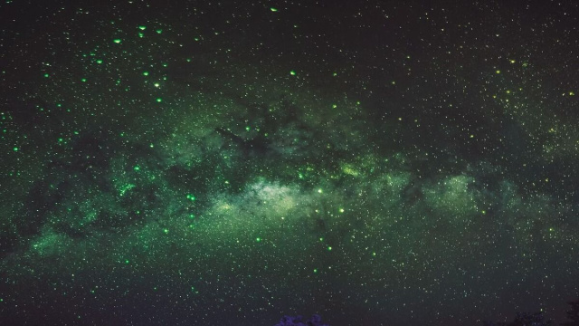 Una galassia che emette una luce verde &copy; Pixabay.
