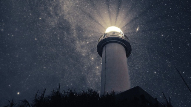 Un faro illuminato sotto un cielo stellato &ndash; &copy; Pixabay.