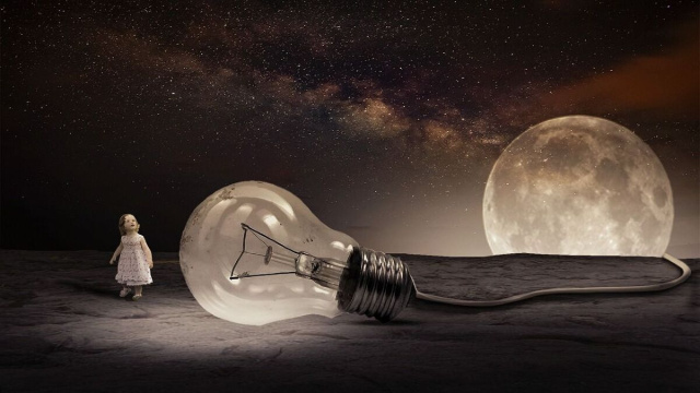 Bambina che guarda un'enorme lampadina collegata alla Luna &copy; Pixabay.
