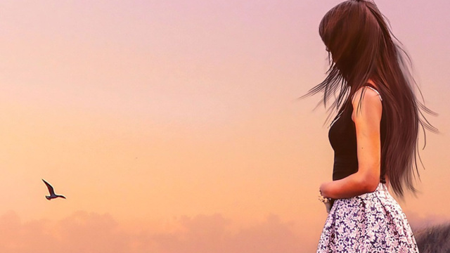 Donna fronte mare con gabbiano in volo - &copy; Pixabay IA.