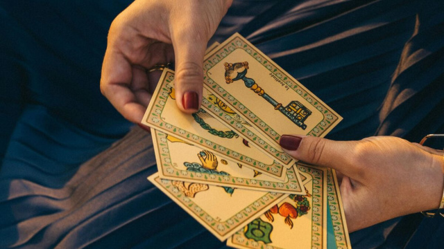 Mani che consultano mazzo di tarocchi-&copy;Pexels