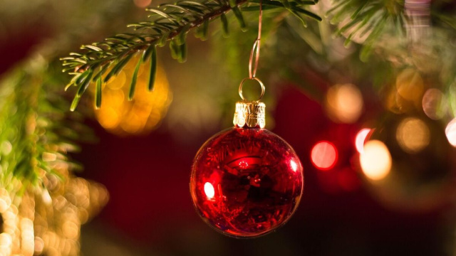 Un ornamento natalizio rosso appeso a un ramo di un albero di Natale &copy; Pixabay.