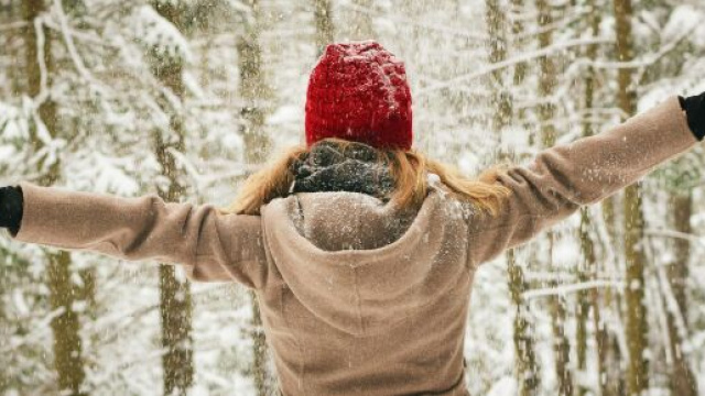 Ragazza nella neve con un cappello rosso &copy; Pexels