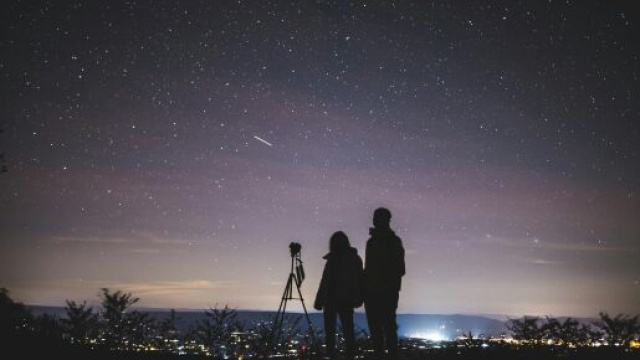 Cielo stellato con una coppia in osservazione - Immagine &copy; Pexels