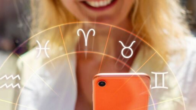 Donna con telefono e ruota dei segni zodiacali &copy; Pixabay.