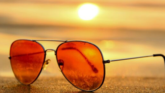 Degli occhiali da sole su una spiaggia al tramonto &copy; Pixabay