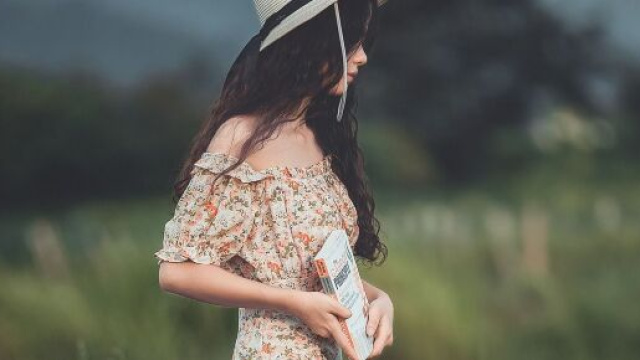 Giovane donna con capello e abito a fiori &copy; Immagine di Pixabay.