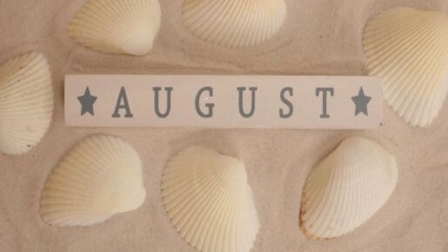 Conchiglie con sabbia e scritta August &copy; Immagine di Pixabay.