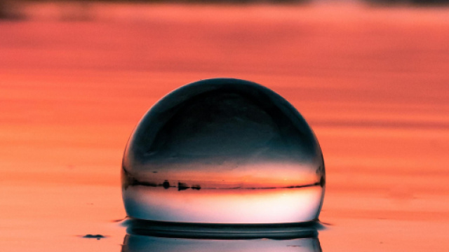 Sfera di cristallo su una spiaggia al tramonto &ndash; &copy; Pexels.