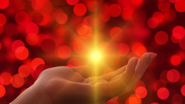 Mano aperta con luce brillante su sfondo bokeh &ndash; &copy; Pixabay IA.