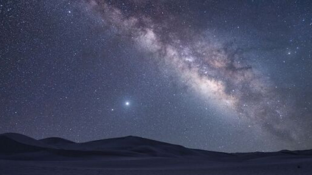 Il deserto, un pianeta lontano e una galassia di stelle &copy; Pixabay.