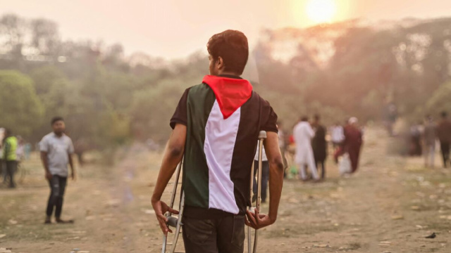 Giovane Con Bandiera Palestinese E Stampelle All'aperto &copy; Ahsanul Haque Z da Pixabay.