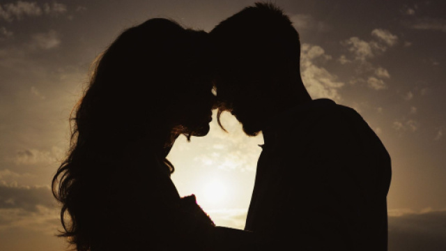 Silhouette di una coppia al tramonto in controluce &ndash; &copy; Pixabay IA.