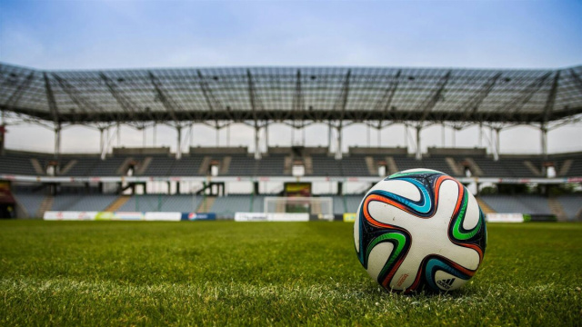 Un campo di calcio e un pallone (Pexels).