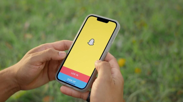 Uno smartphone e il logo di Snapchat (Snapchat).