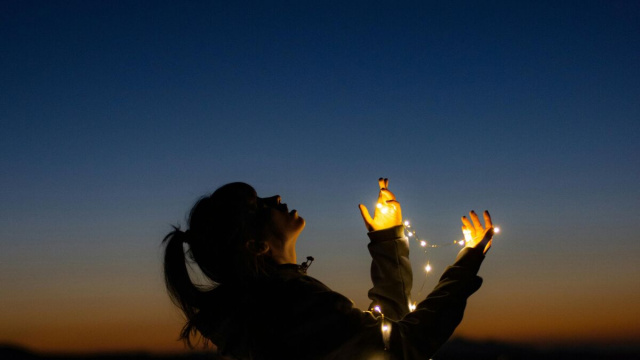 Donna cib luminarie che guarda il cielo- &copy; Pexels
