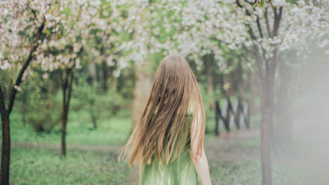Ragazza che osserva gli alberi in fiore -&copy;Pexels