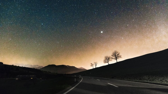 Una strada asfaltata sotto un cielo stellato al tramonto - pixabay.com