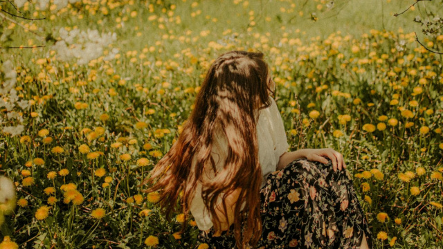 Ragazza seduta in giardino di fiori- &copy; Pexels