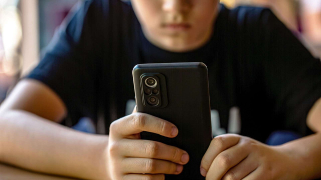 Un adolescente davanti ad uno smartphone